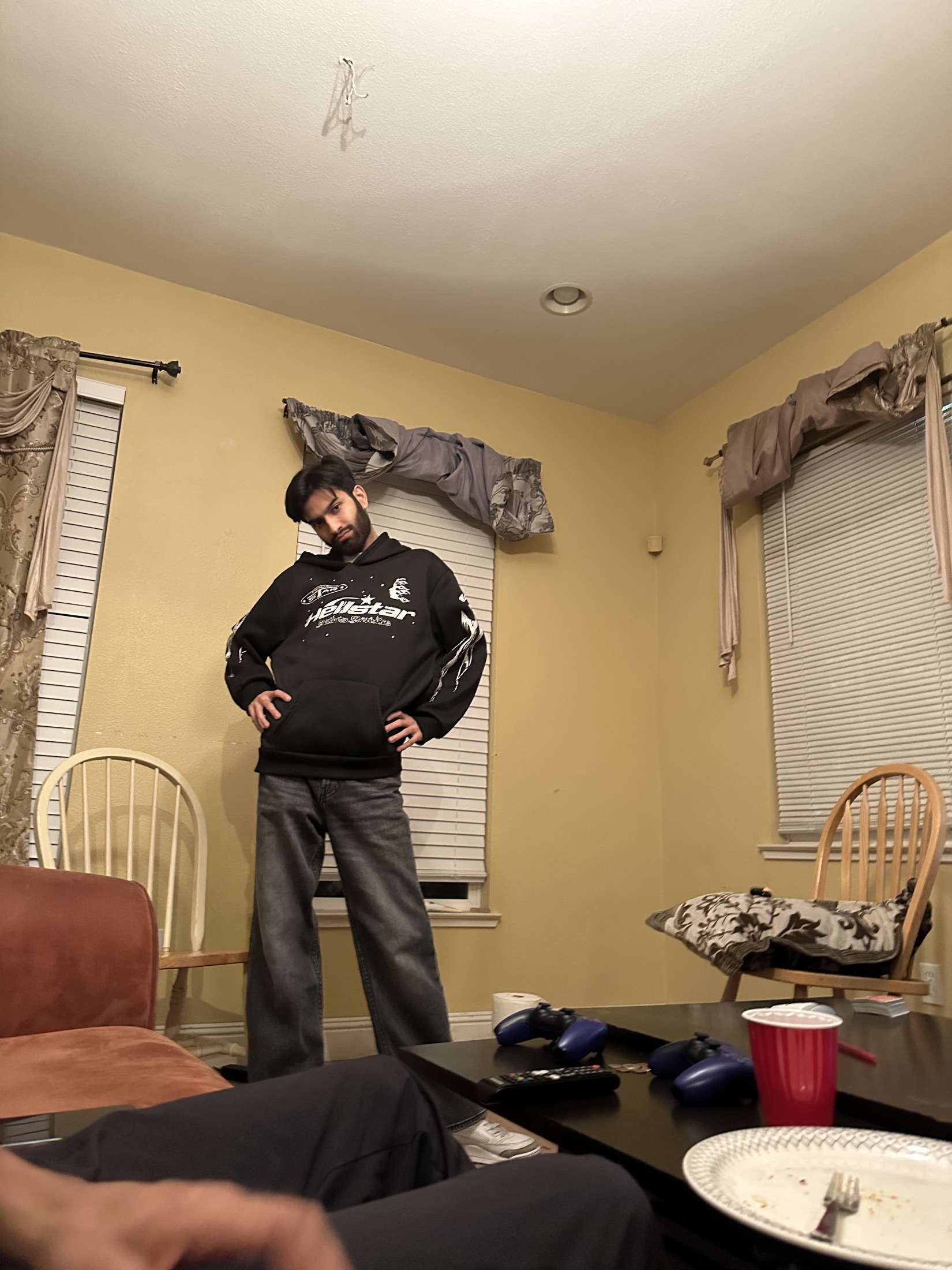 Kartik in a black hoodie posing with hands on hips